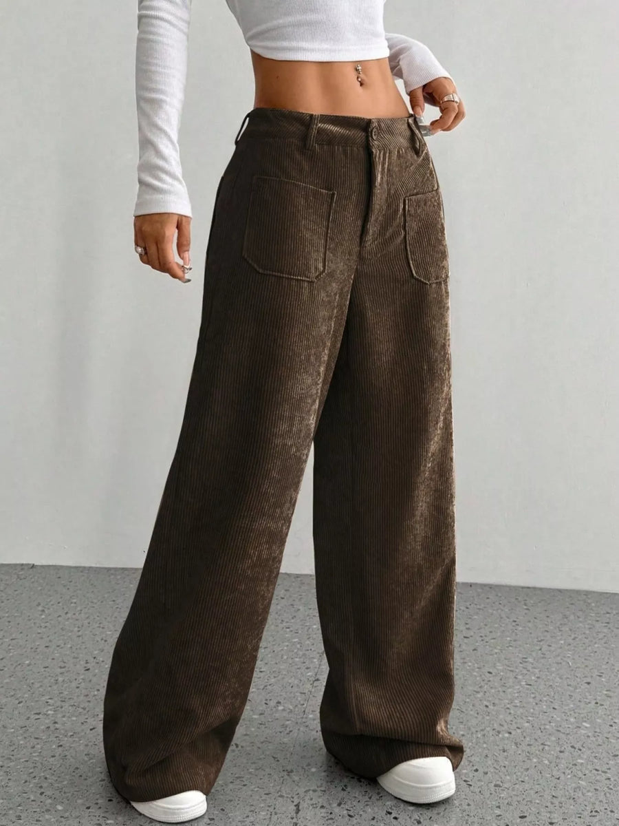 Person wearing brown wide-leg pants with a plain background