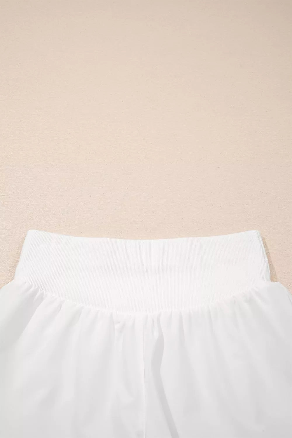 White pants on a beige background