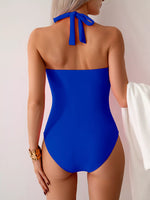 Blue swimsuit with a halter neck design on a plain background