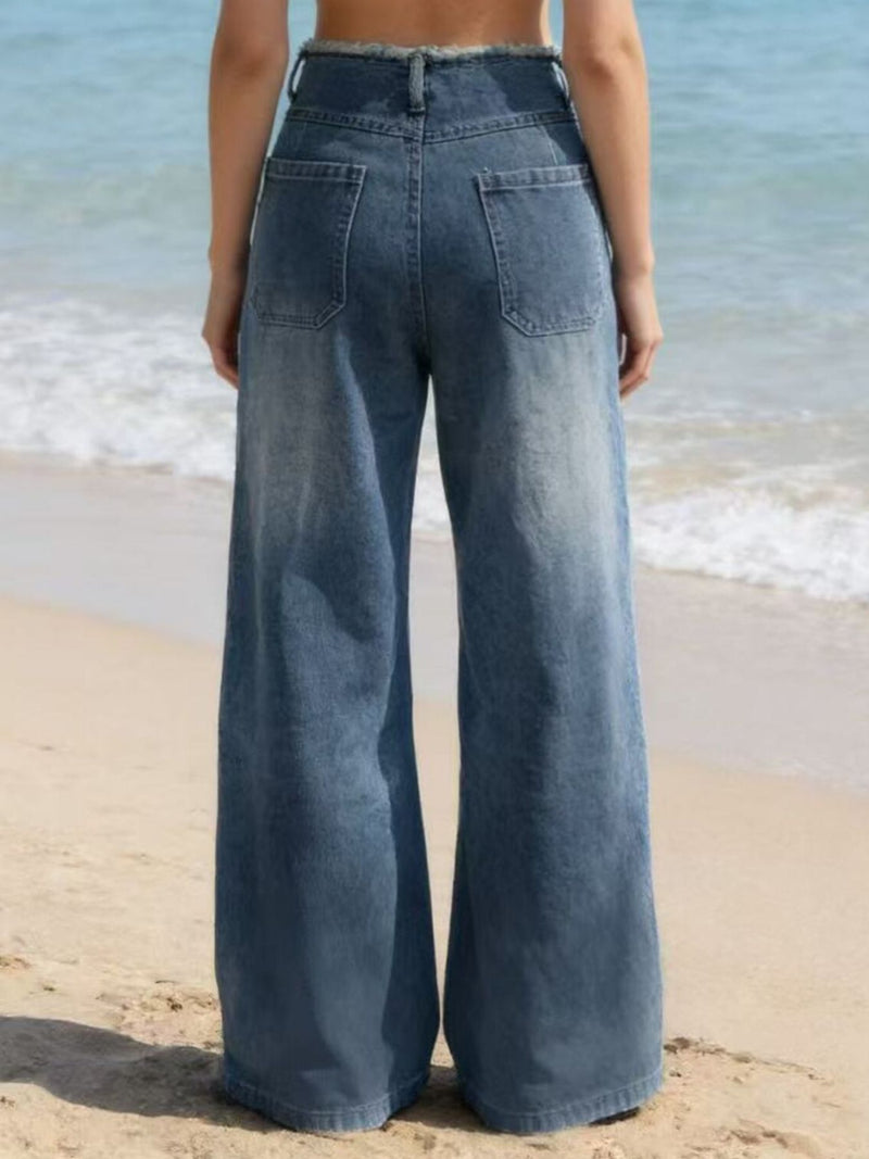 Person wearing wide-leg jeans on a beach