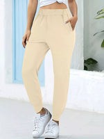 Person wearing beige pants and white sneakers in a bright outdoor setting