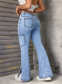 Person wearing light blue flared jeans with a concrete wall background