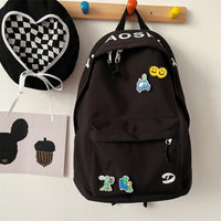 Black backpack with colorful patches on a white surface