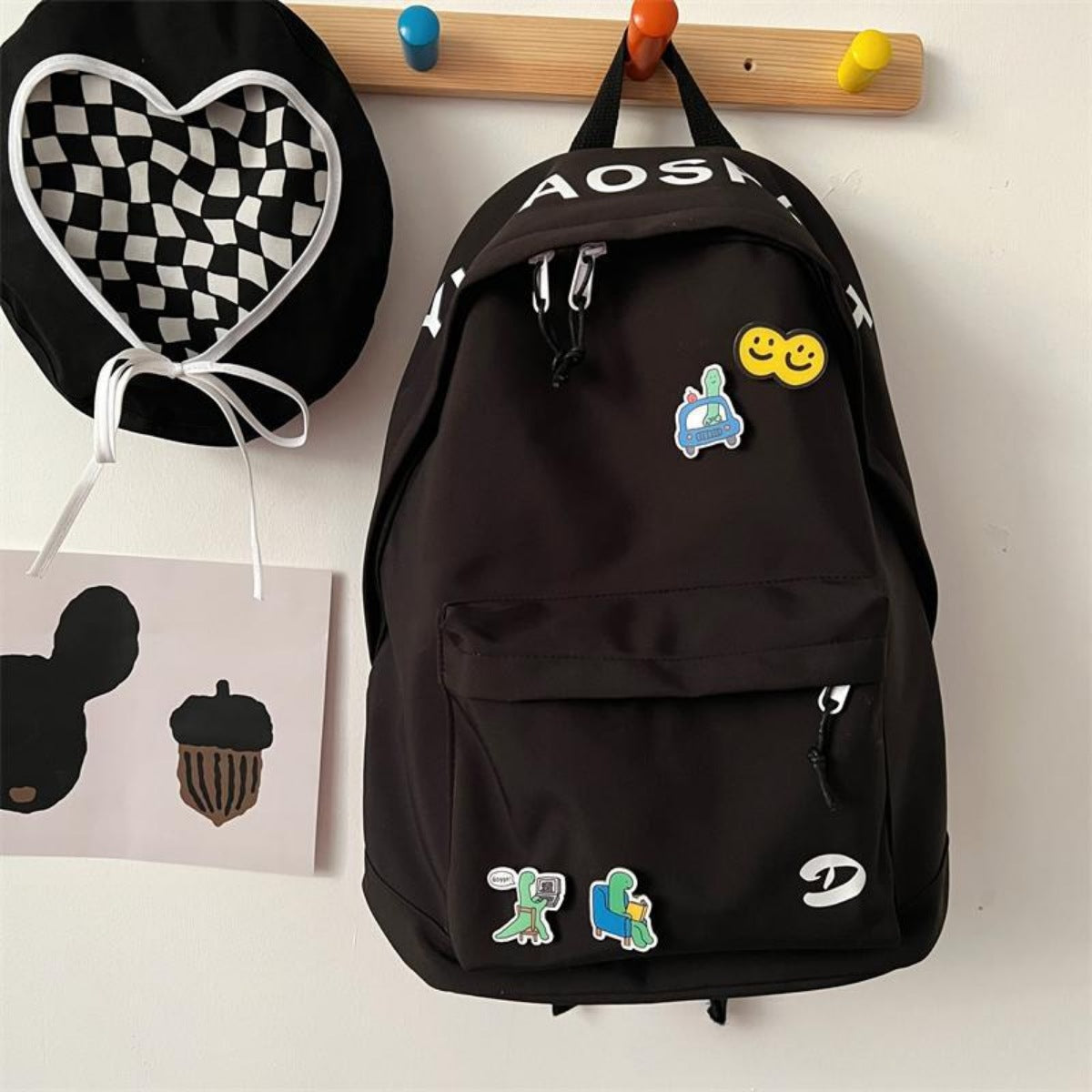 Black backpack with colorful patches on a white surface