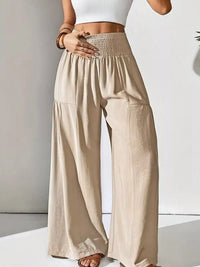 Beige wide-leg pants worn by a person on a white background