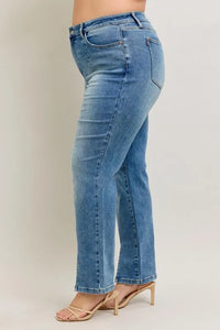 Blue jeans worn by a person on a plain background