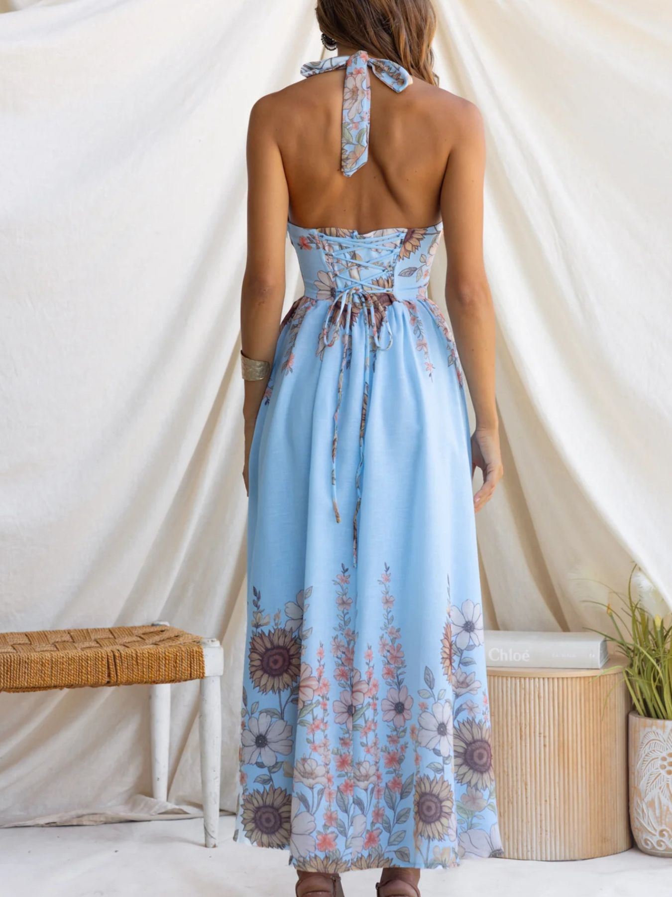 Woman wearing a light blue floral dress with a white background