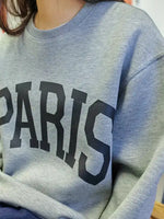 Close up view of the word Paris on the front of Basic Bae PARIS Round Neck Long Sleeve Air Scuba Sweatshirt