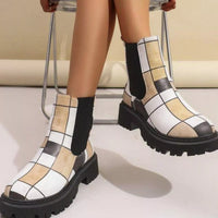 Checkered patterned boots worn by a person sitting on a chair.