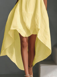 Yellow dress with a high-low hemline on a gray background