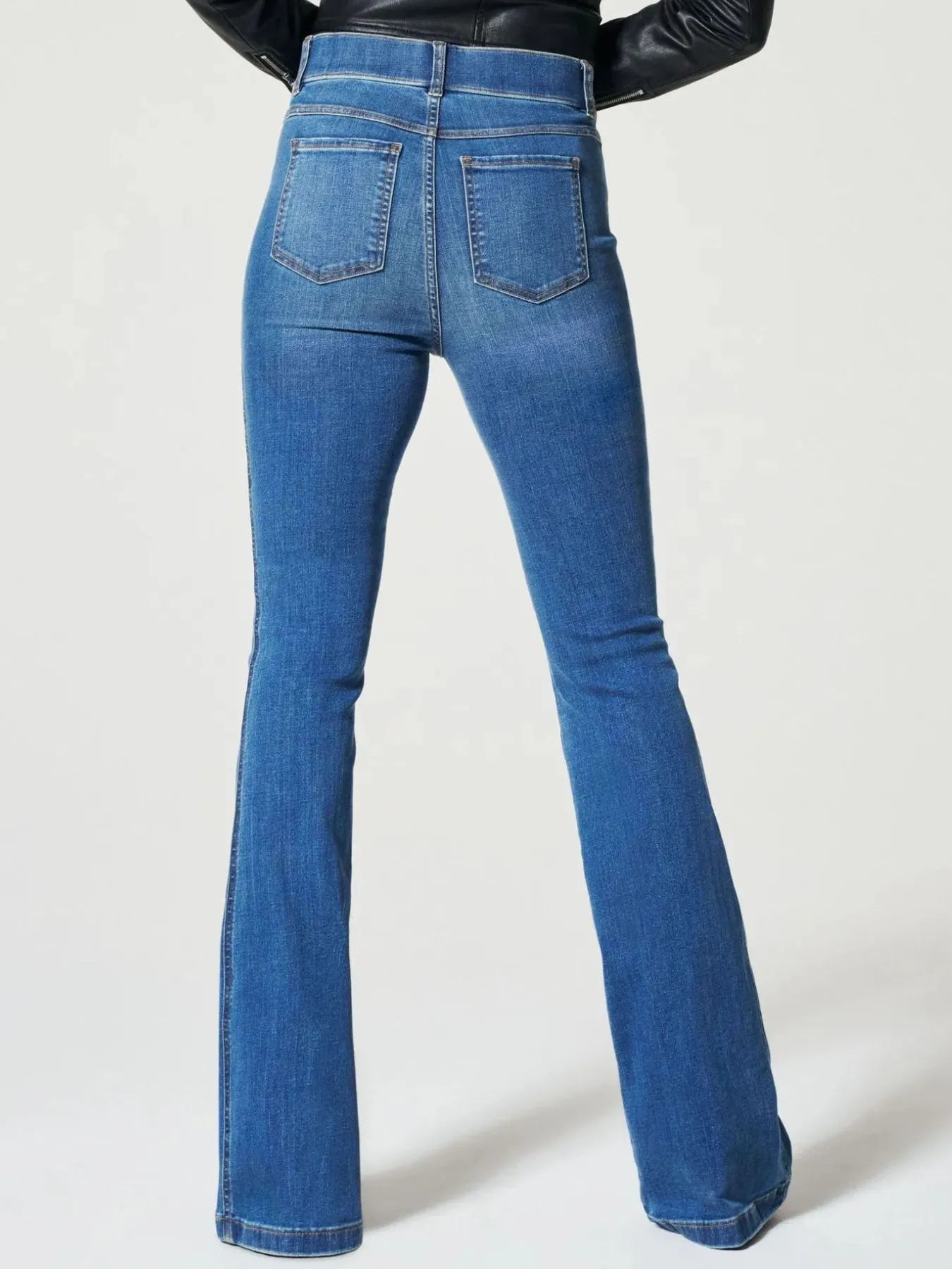 Blue jeans worn by a person on a white background
