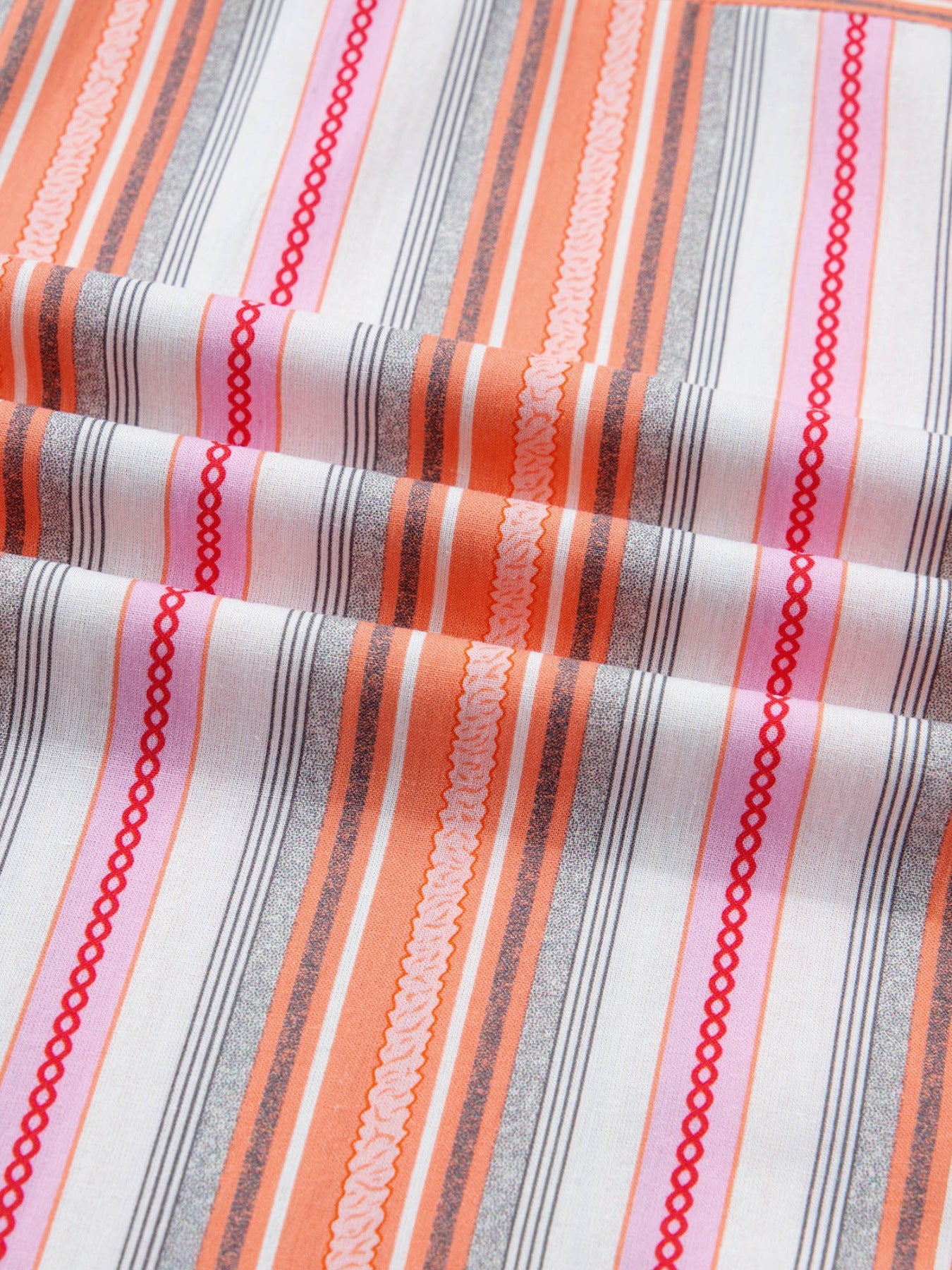 Close-up of striped fabric with red, orange, and gray lines on a white background