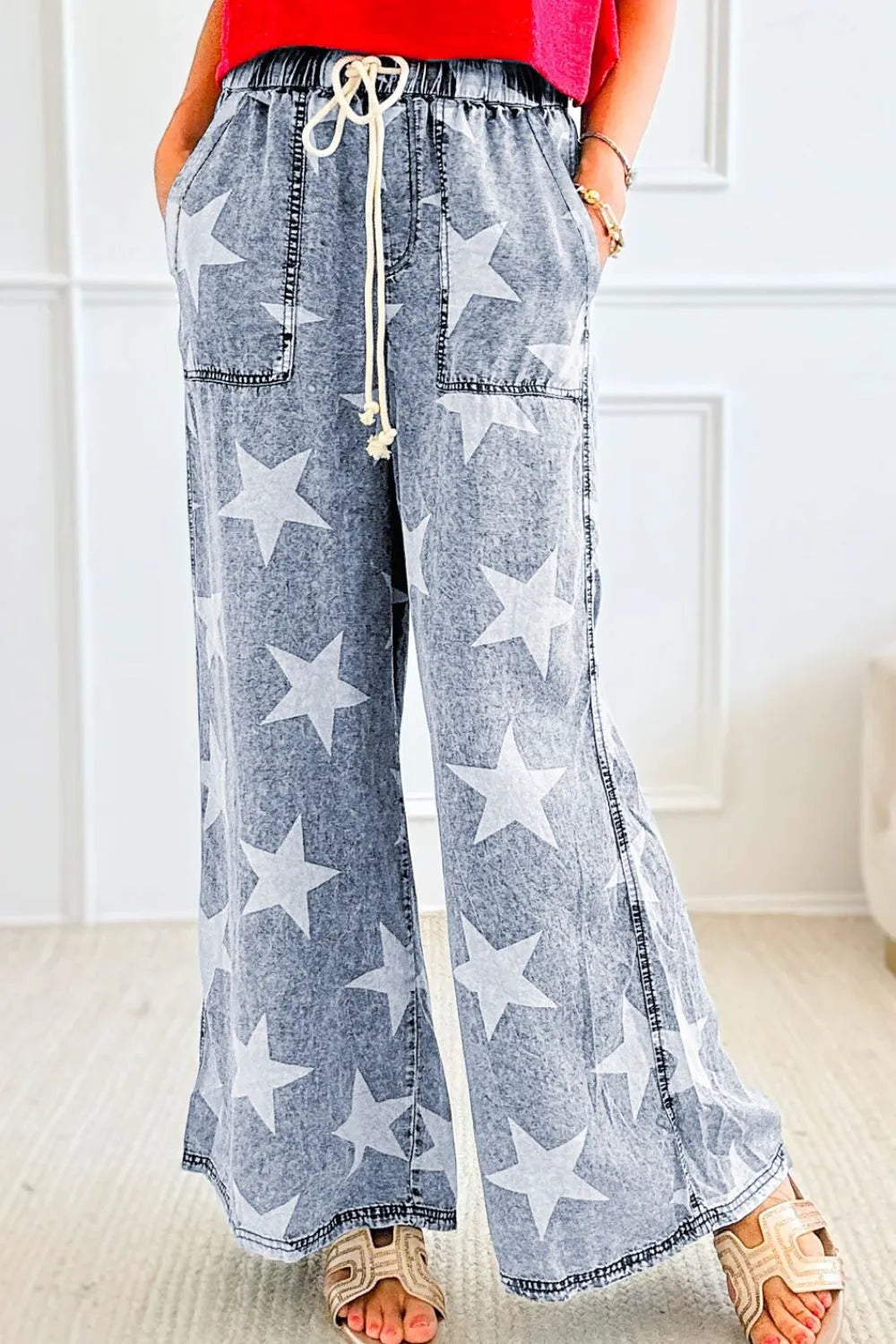 Blue denim pants with star patterns worn by a person indoors.
