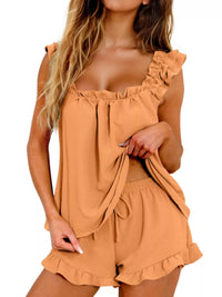 Woman wearing a tan romper with ruffled details on a white background