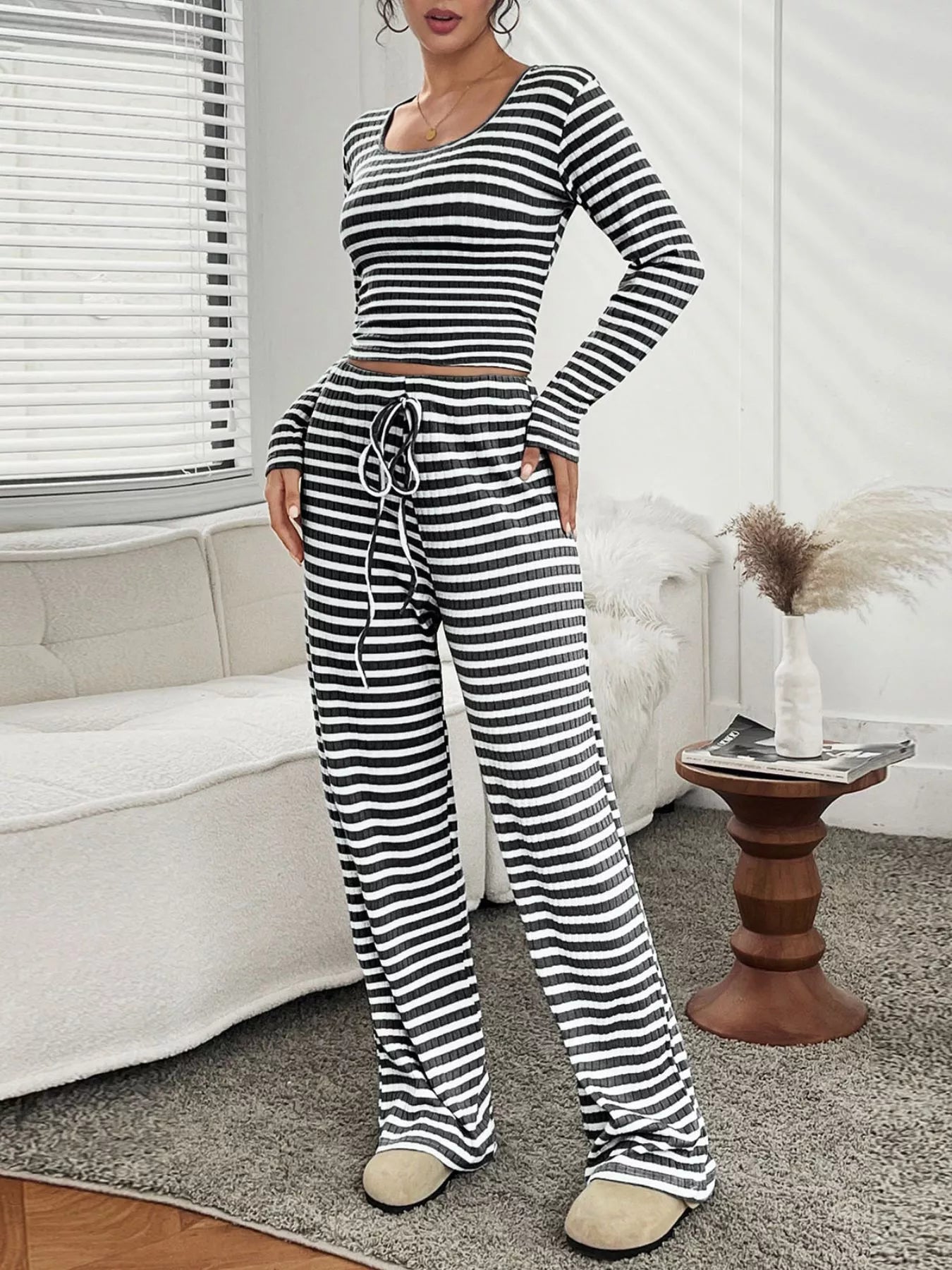 Person wearing a black and white striped outfit in a living room setting.