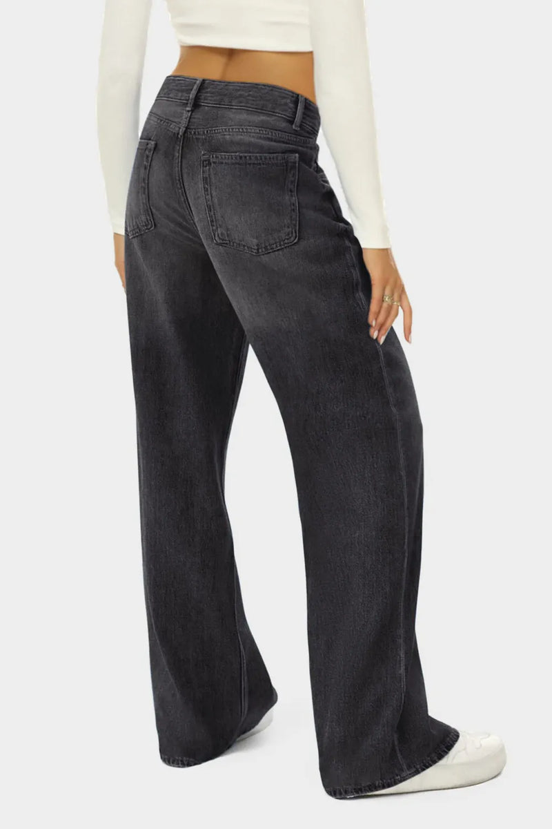 Person wearing black wide-leg jeans on a white background