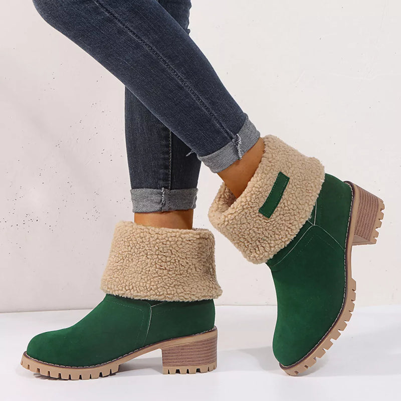 Green ankle boots with beige shearling lining worn with jeans on a white background