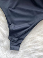 Navy blue swimsuit bottom on a white textured surface