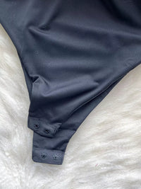 Navy blue swimsuit bottom on a white textured surface