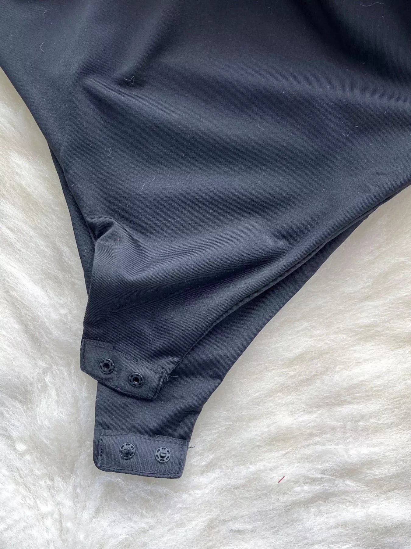 Navy blue swimsuit bottom on a white textured surface