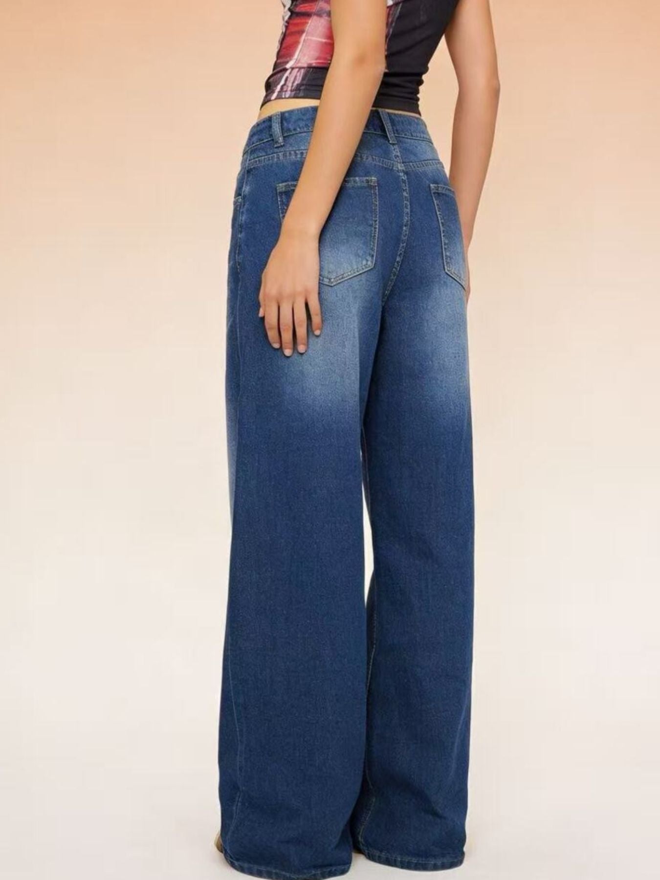 Wide-leg jeans worn by a person on a beige background