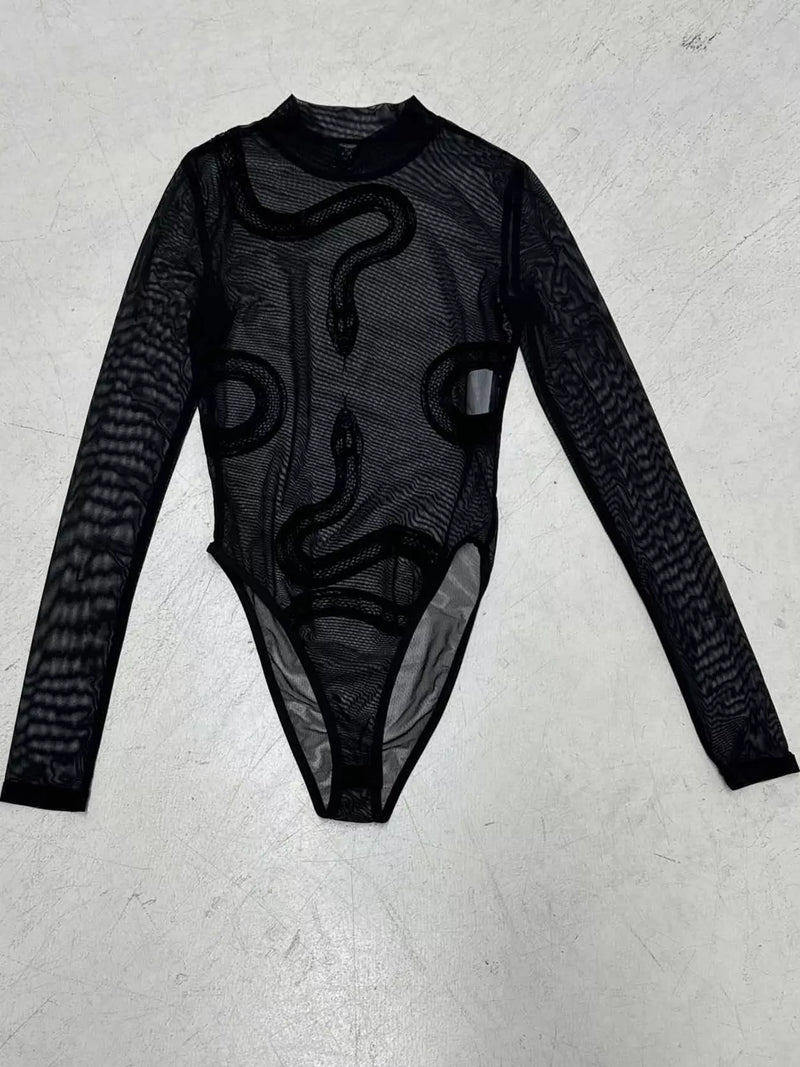 A black long-sleeve sheer mesh bodysuit with a snake graphic print, laid flat on a light gray textured surface.