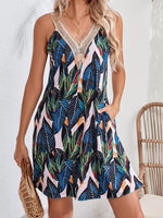 Woman wearing a colorful leaf-patterned dress with a white background