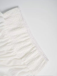 Close-up of a textured white fabric on a light gray background
