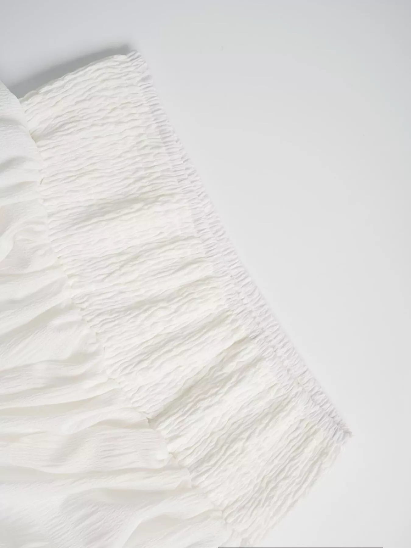 Close-up of a textured white fabric on a light gray background