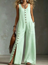 Woman wearing a light green jumpsuit with button details against a neutral background