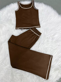 Brown sleeveless top and pants set on a white fluffy surface