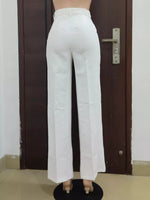 White pants displayed against a dark brown door.