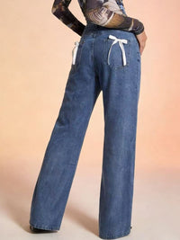 Blue jeans with white drawstring on a beige background