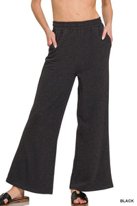 Black wide-leg pants worn by a person on a white background