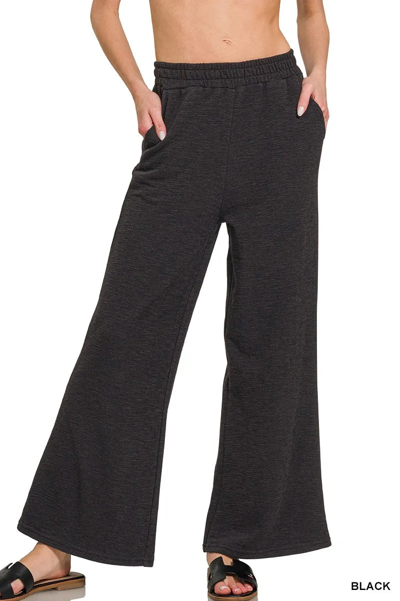 Black wide-leg pants worn by a person on a white background