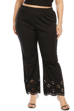 Black pants with floral cut-out details on a white background