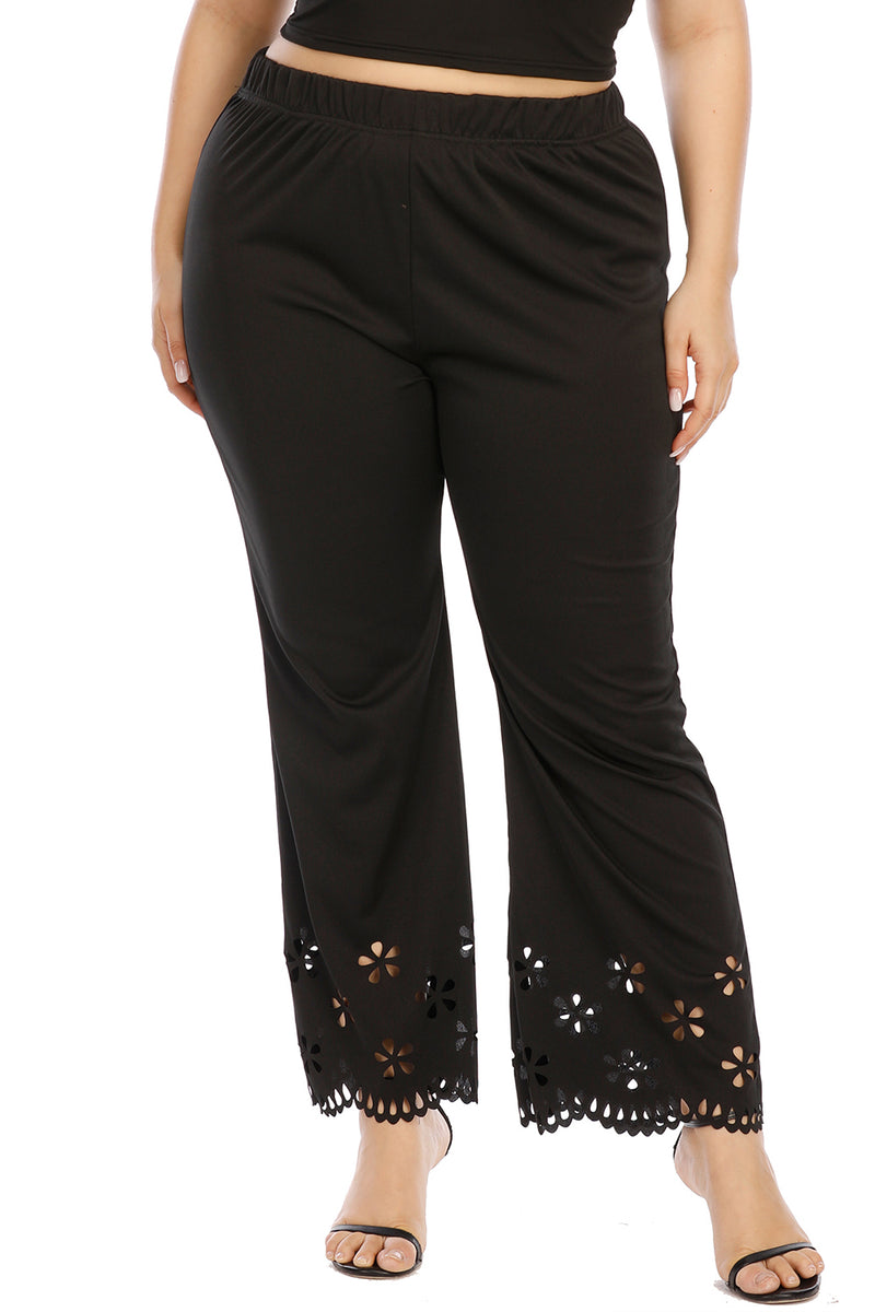Black pants with floral cut-out details on a white background