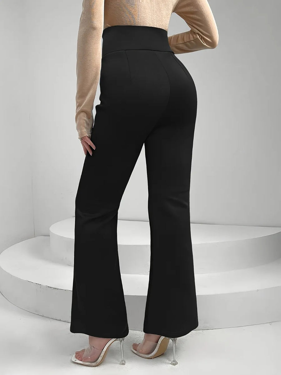 Person wearing black flared pants on a white background