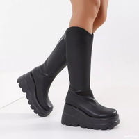 Black knee-high platform boots on a white background