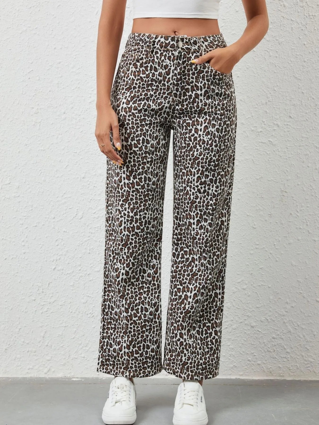 Leopard print pants worn by a person against a plain background