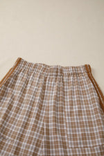 Plaid pants with brown and white pattern on a beige background