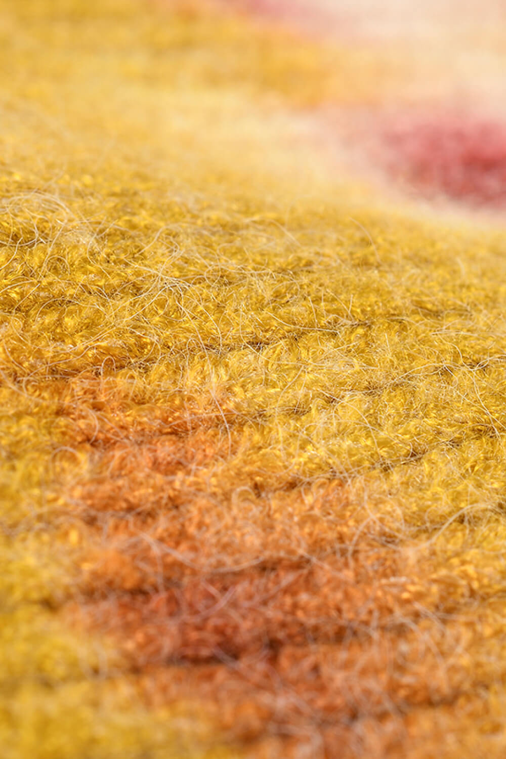 Close-up of a textured fabric with yellow and orange hues