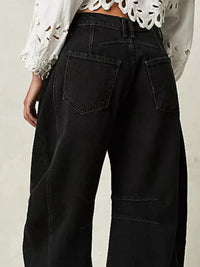 Black wide-leg jeans worn by a person on a neutral background