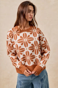 Woman wearing a brown and white patterned sweater against a beige background