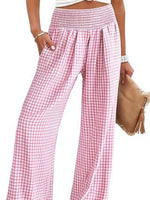 Pink checkered pants worn by a person on a white background