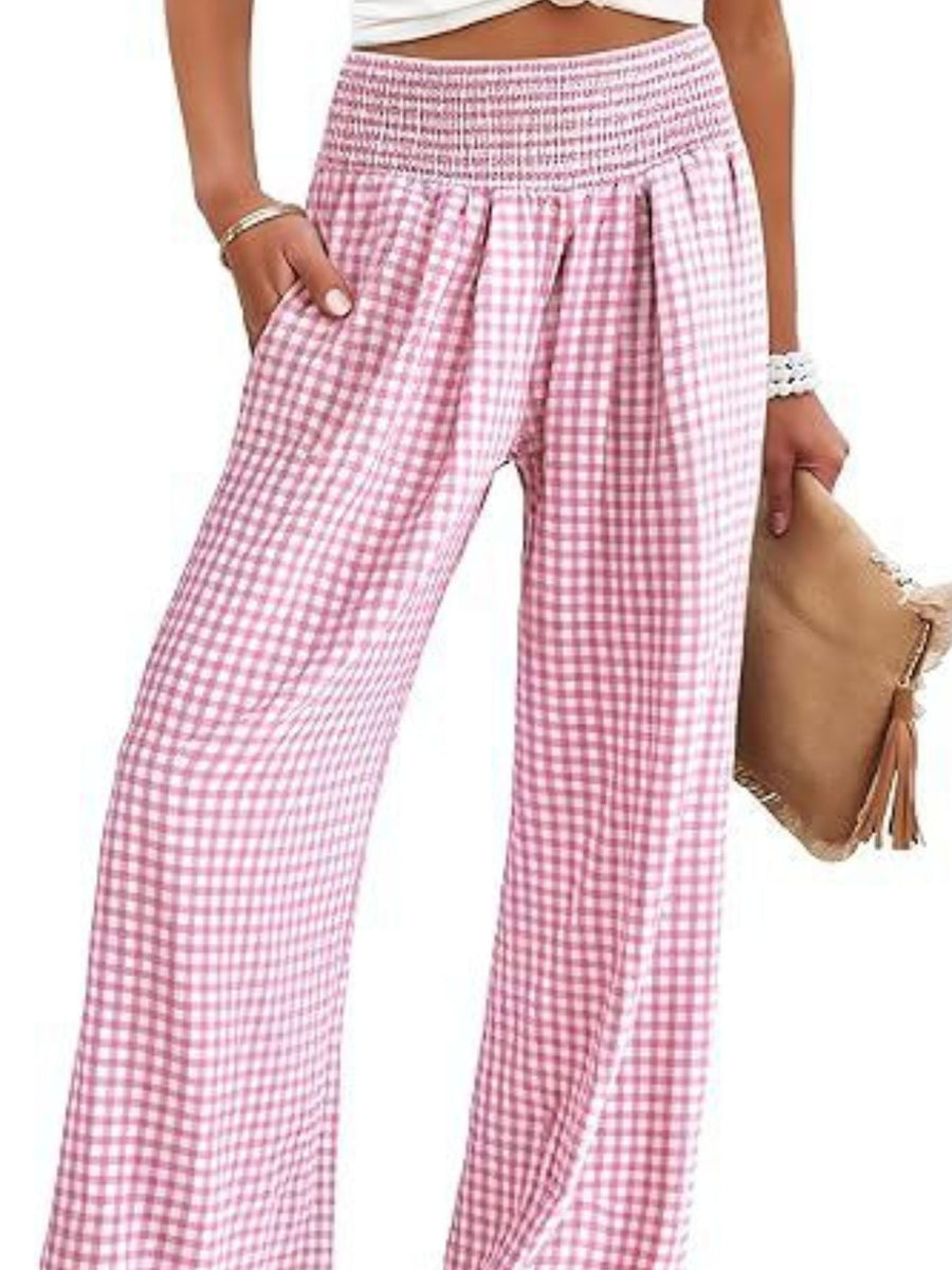 Pink checkered pants worn by a person on a white background