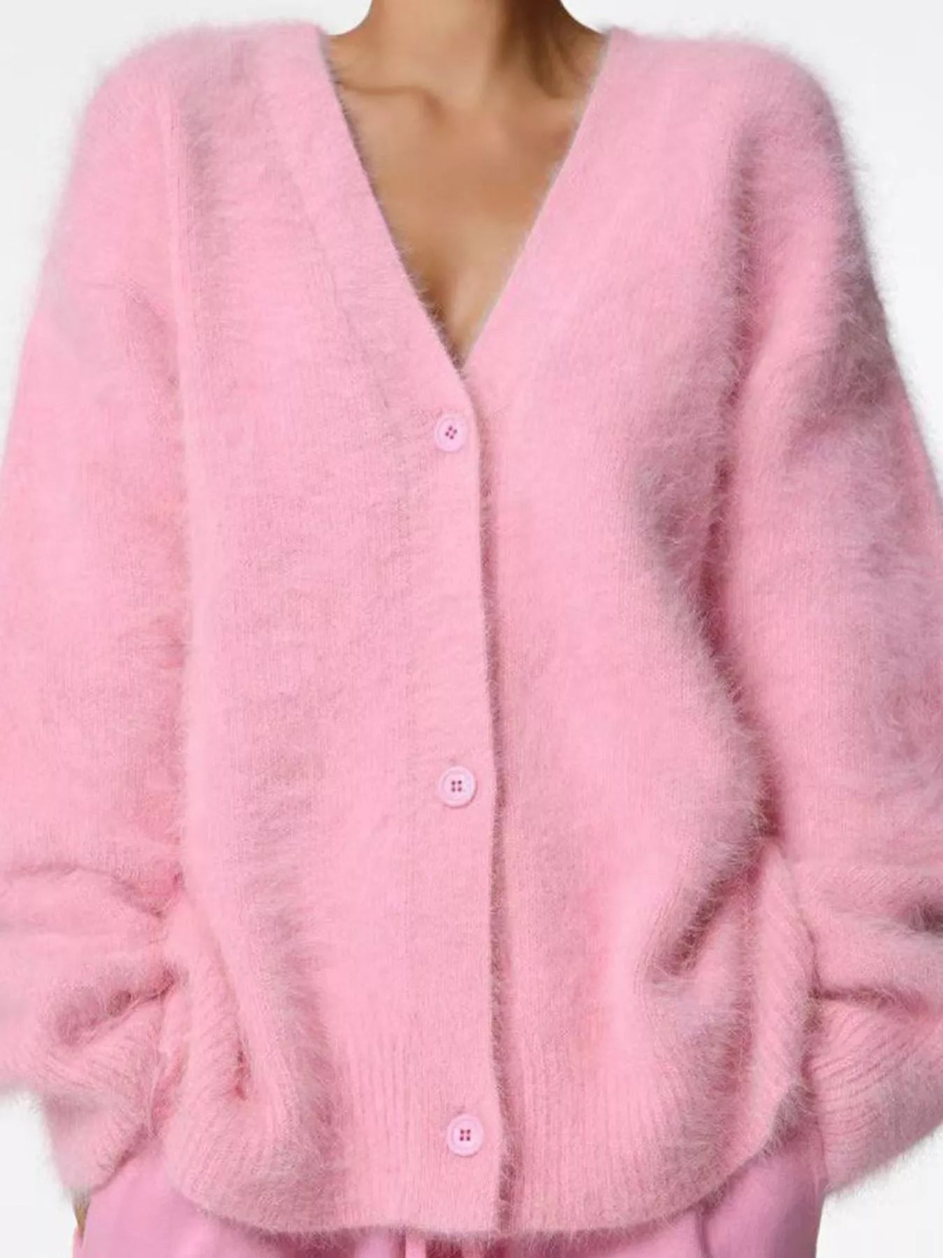 Pink cardigan worn by a person on a white background