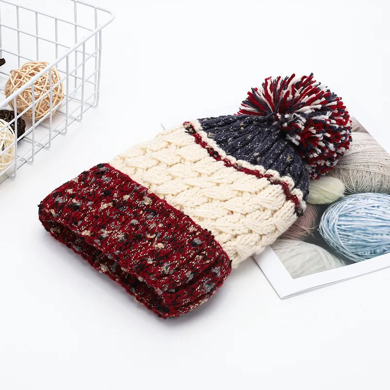 Knitted blanket with a pom-pom on a white surface