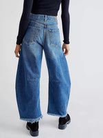 Person wearing blue jeans on a plain background