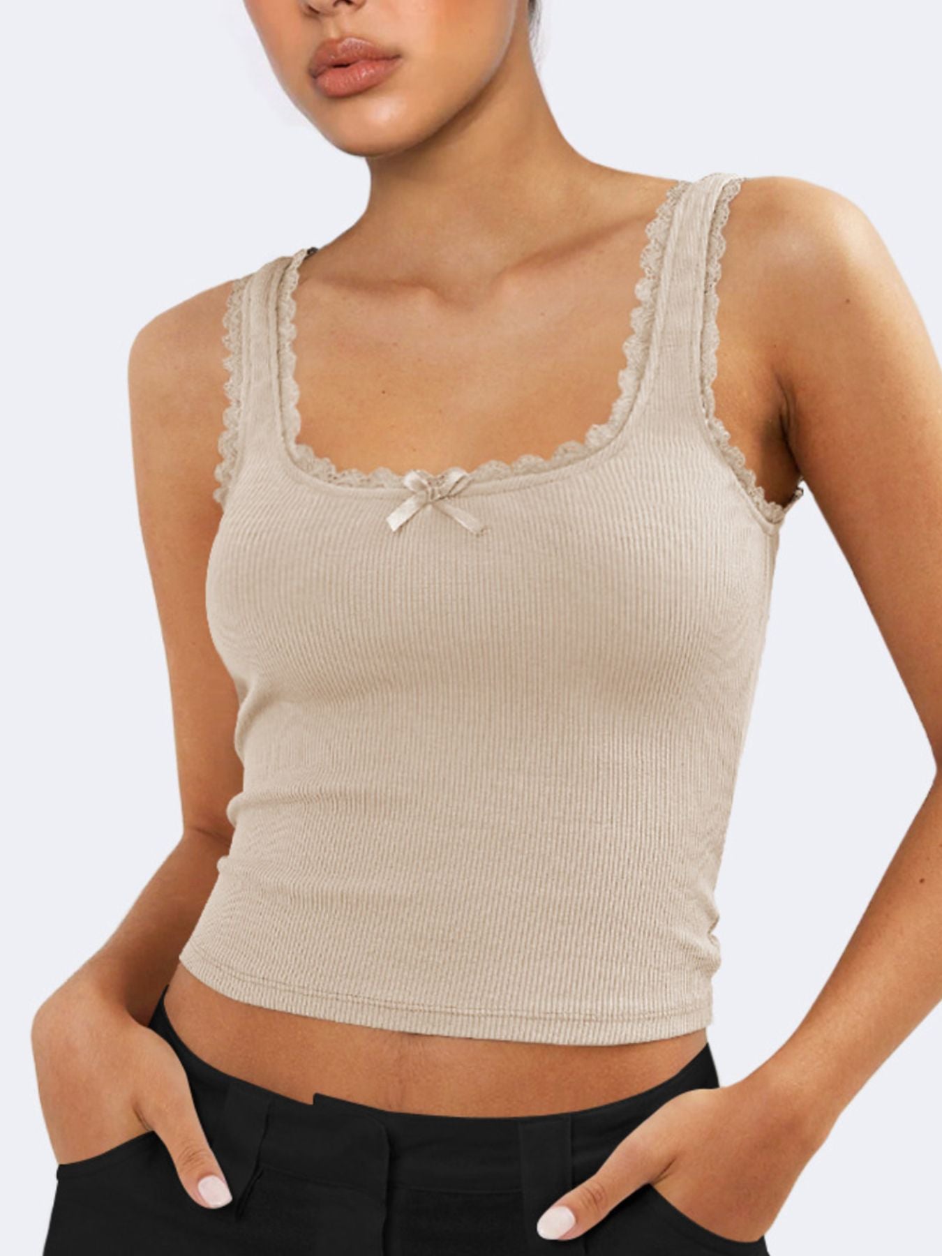 Beige ribbed tank top with lace trim worn by a person on a light gray background